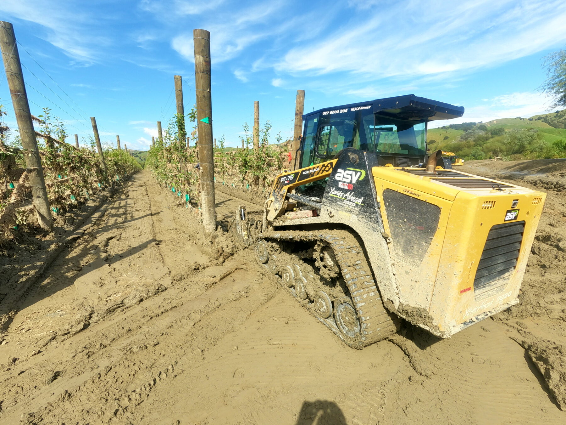 ASV skid steer clearing silt from an orchard row